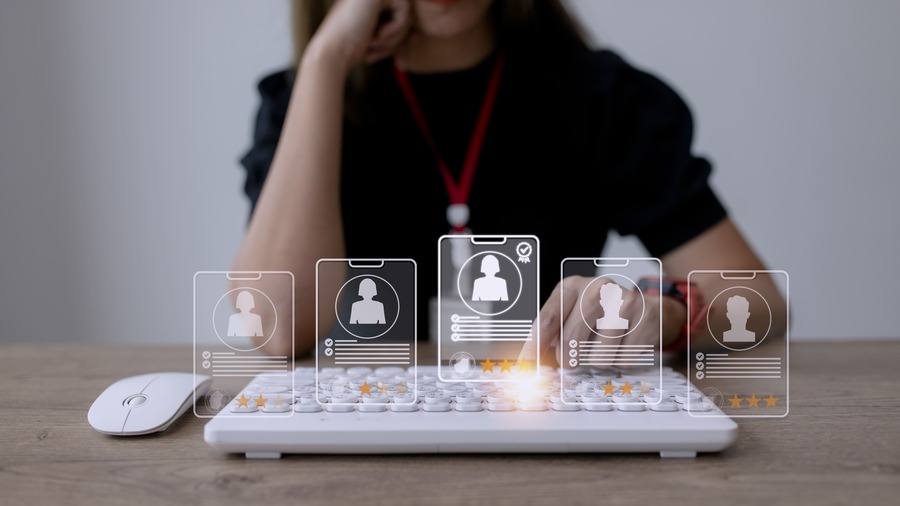 HR software for business owner reviewing digital employee profiles on keyboard interface.