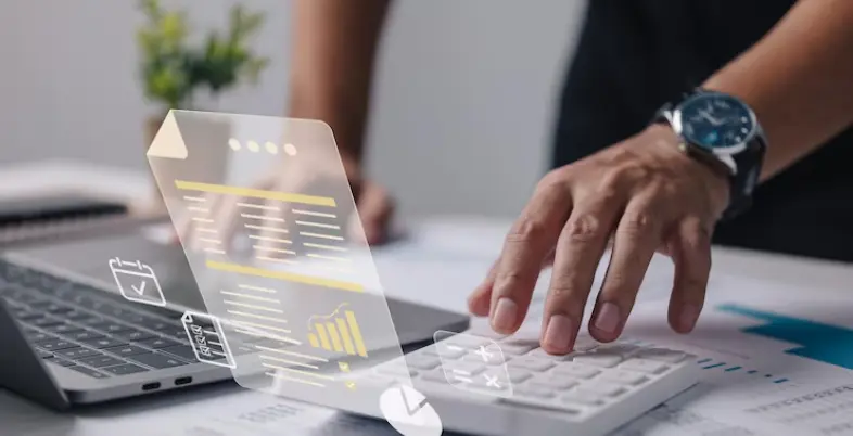 Business professional using HRMS Dubai software on laptop and calculator, showcasing payroll analytics and digital HR tools on a virtual interface.