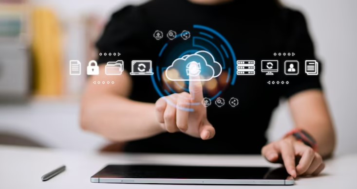 A person interacting with digital icons representing a Cloud-Based HRMS in UAE, including cloud storage, security, employee profiles, and data servers on a virtual touchscreen above a tablet.