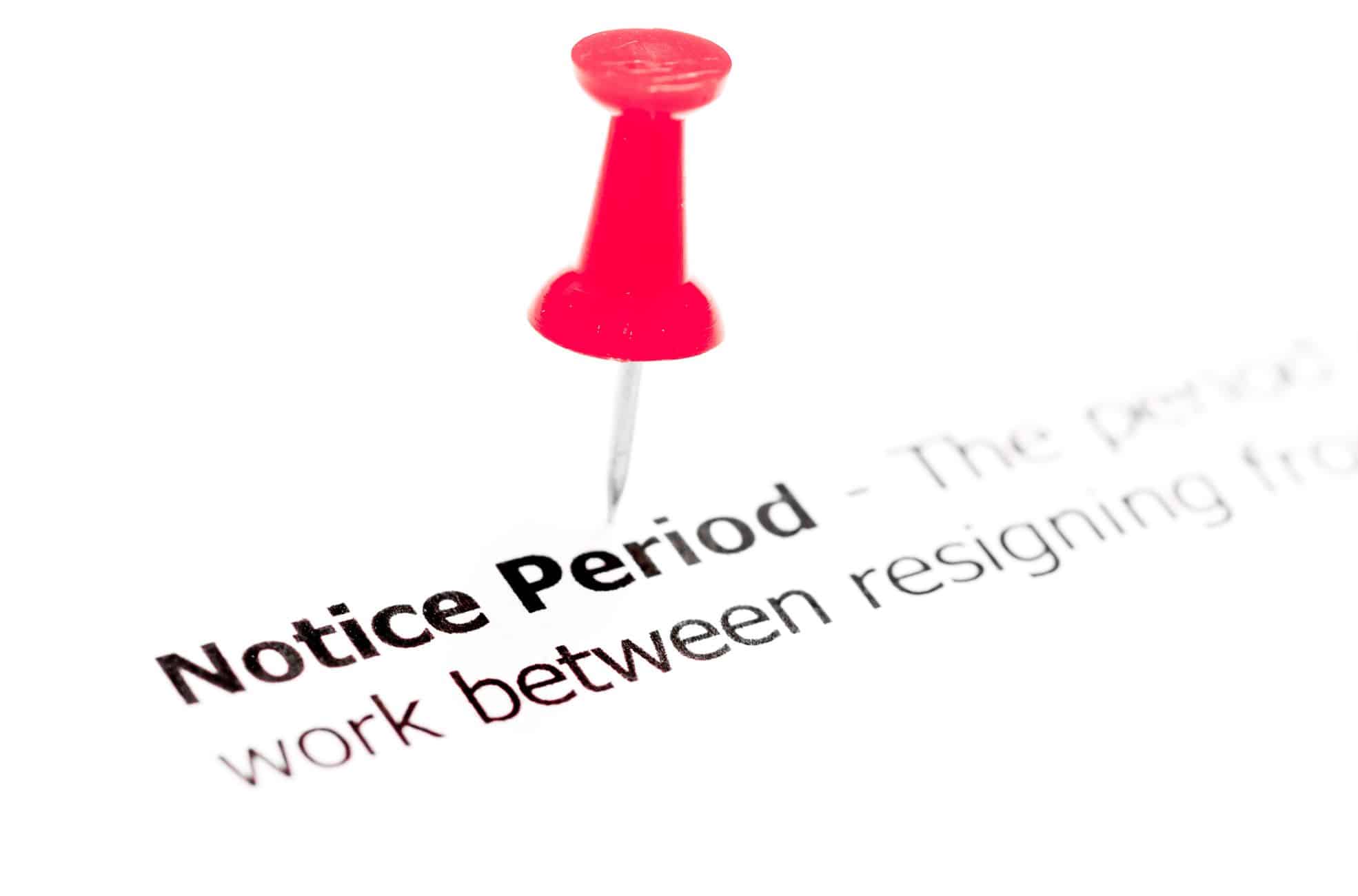 Red pushpin highlighting Notice Period in UAE text on employment document, illustrating resignation and work transition concepts