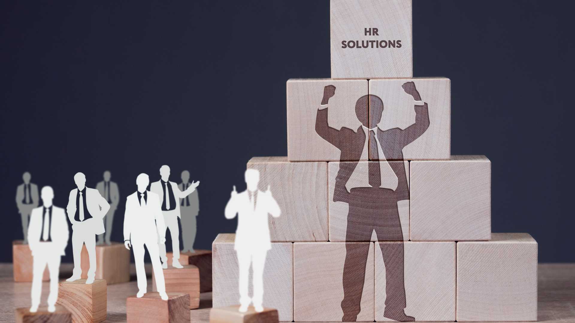 Wooden blocks forming a pyramid with silhouettes of business professionals and the text "HR Solutions" on top, symbolizing teamwork and success — concept for the Best HR Software for Karachi Businesses.