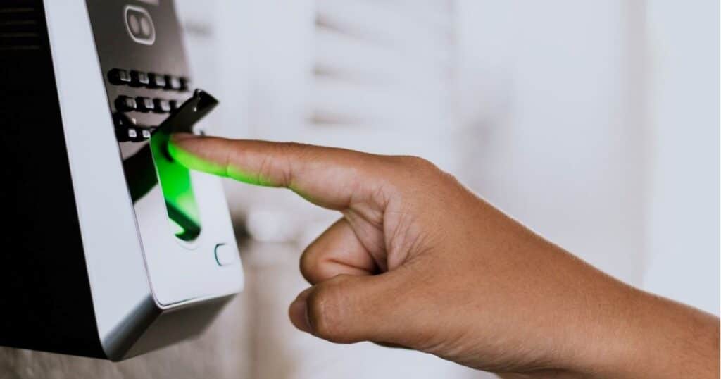 Close-up of a person using a fingerprint scanner for attendance verification — concept of Biometric Attendance Integration in HRMS Pakistan to enhance employee tracking and workplace automation.