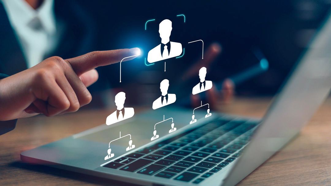 Free HRMS Trial Pakistan showing a digital HR interface on a laptop with employee hierarchy icons, illustrating automated HR processes and workforce management.